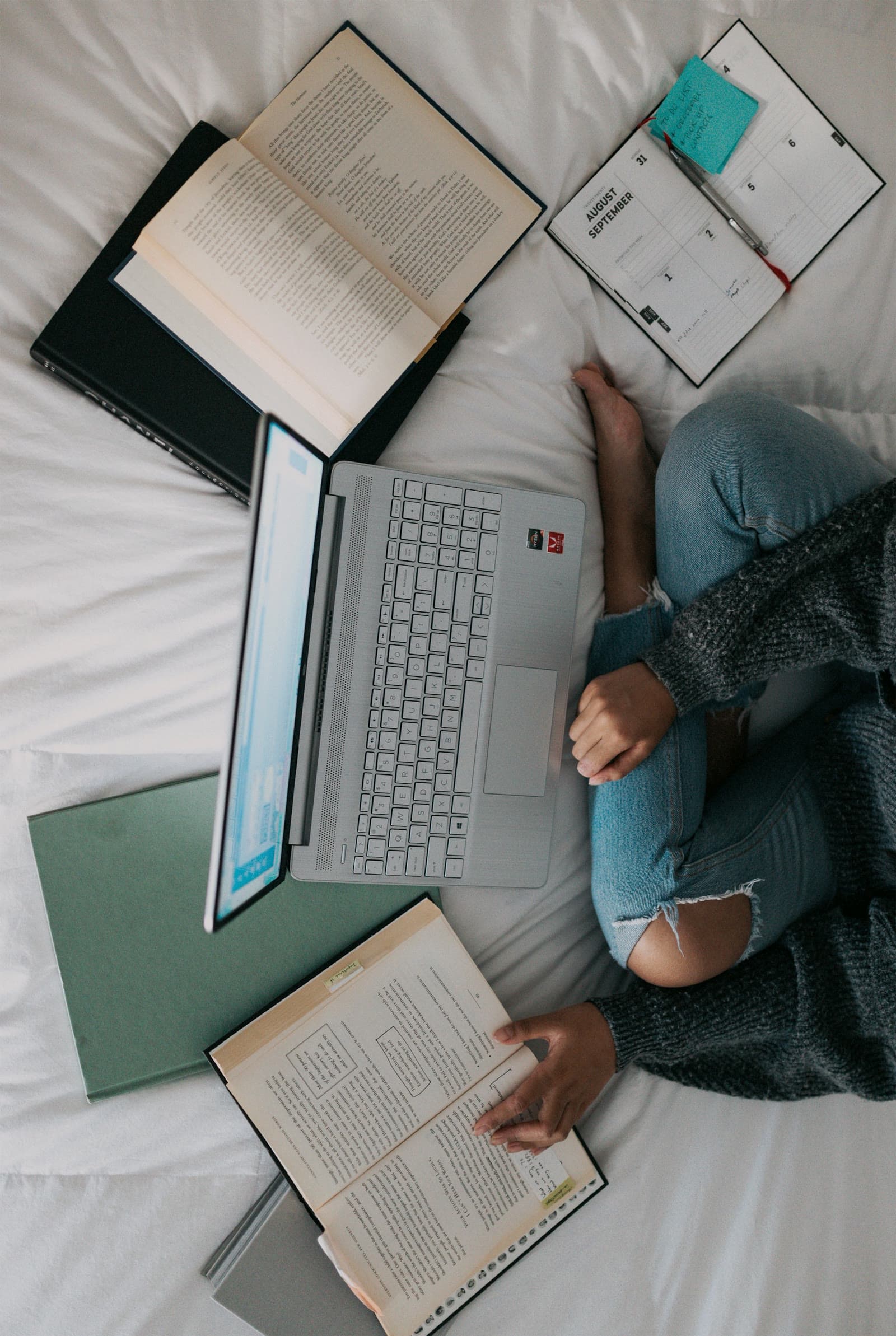 A practitioner studying with a laptop and notes